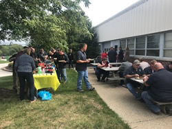A group of Solon employees outside having a picnic at a set of tables